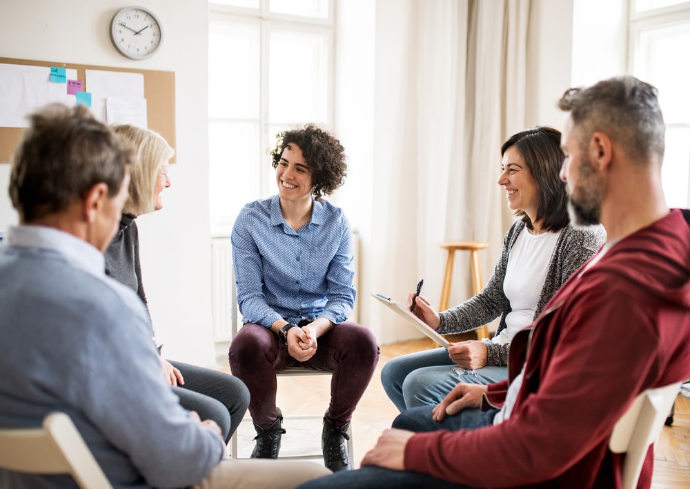People sit in a circle and participate in group therapy at a residential eating disorder treatment center