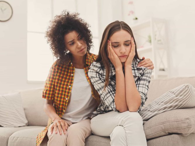 A woman puts an arm around her friend to show support