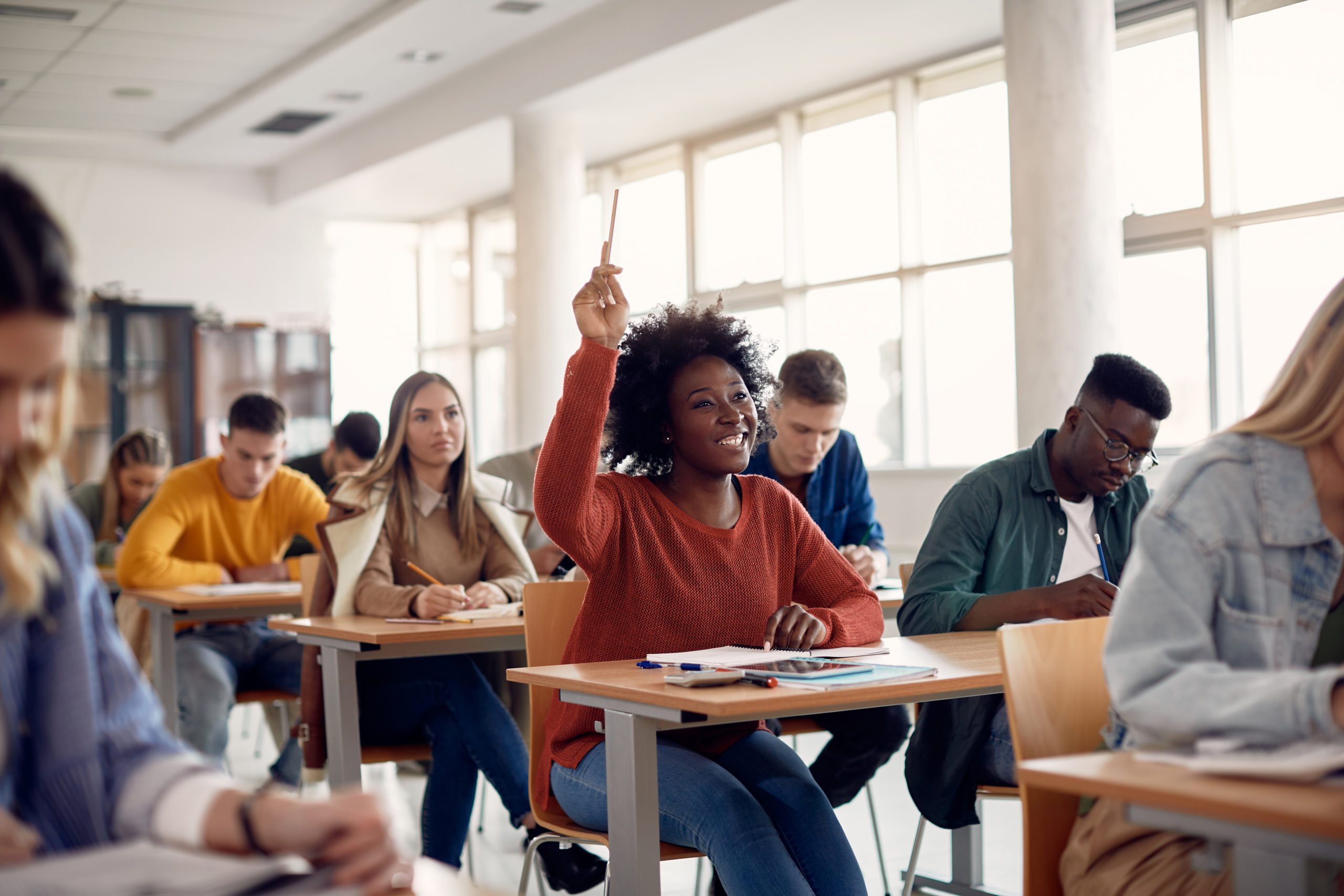 happy-african-american-student-raising-her-hand-to-ask-a-question-during-lecture-in-the-classroom-stockpack-istock