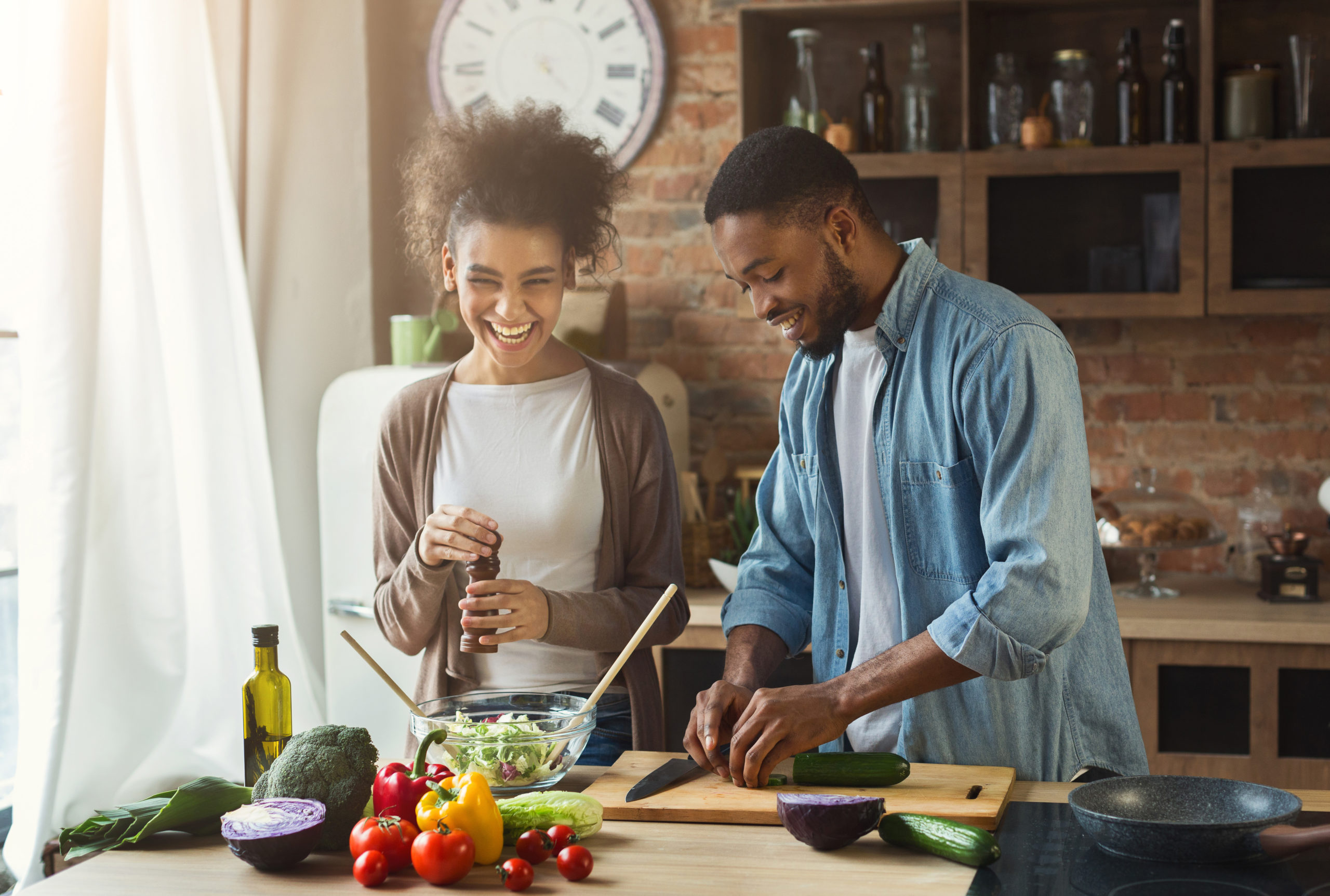 laughing-black-couple-preparing-healthy-salad-together-in-loft-kitchen-young-family-cooking-dinner-stockpack-istock