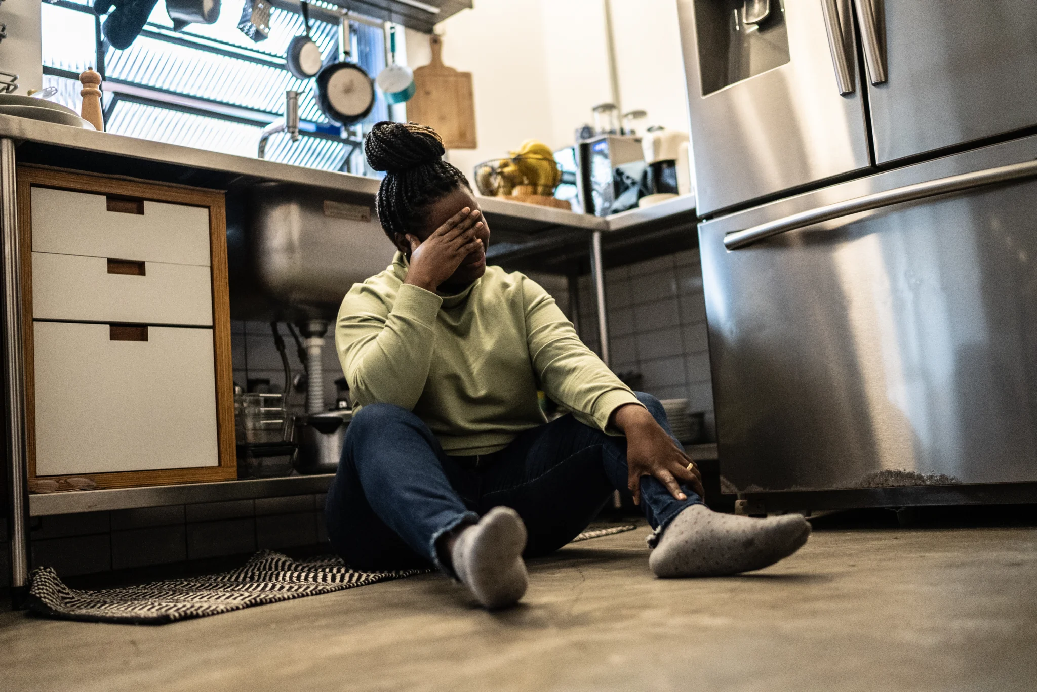 Sad mid adult woman in the kitchen at home