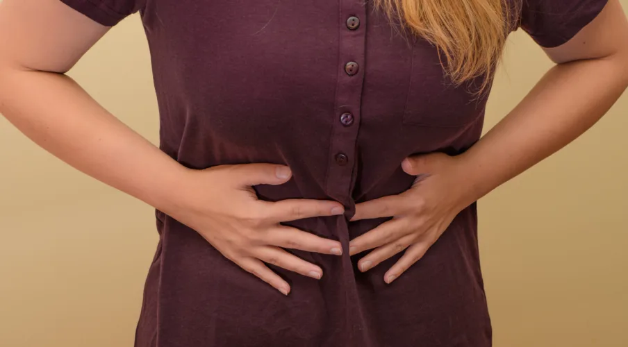 Woman holding her stomach, stomach pain in the middle closeup isolated