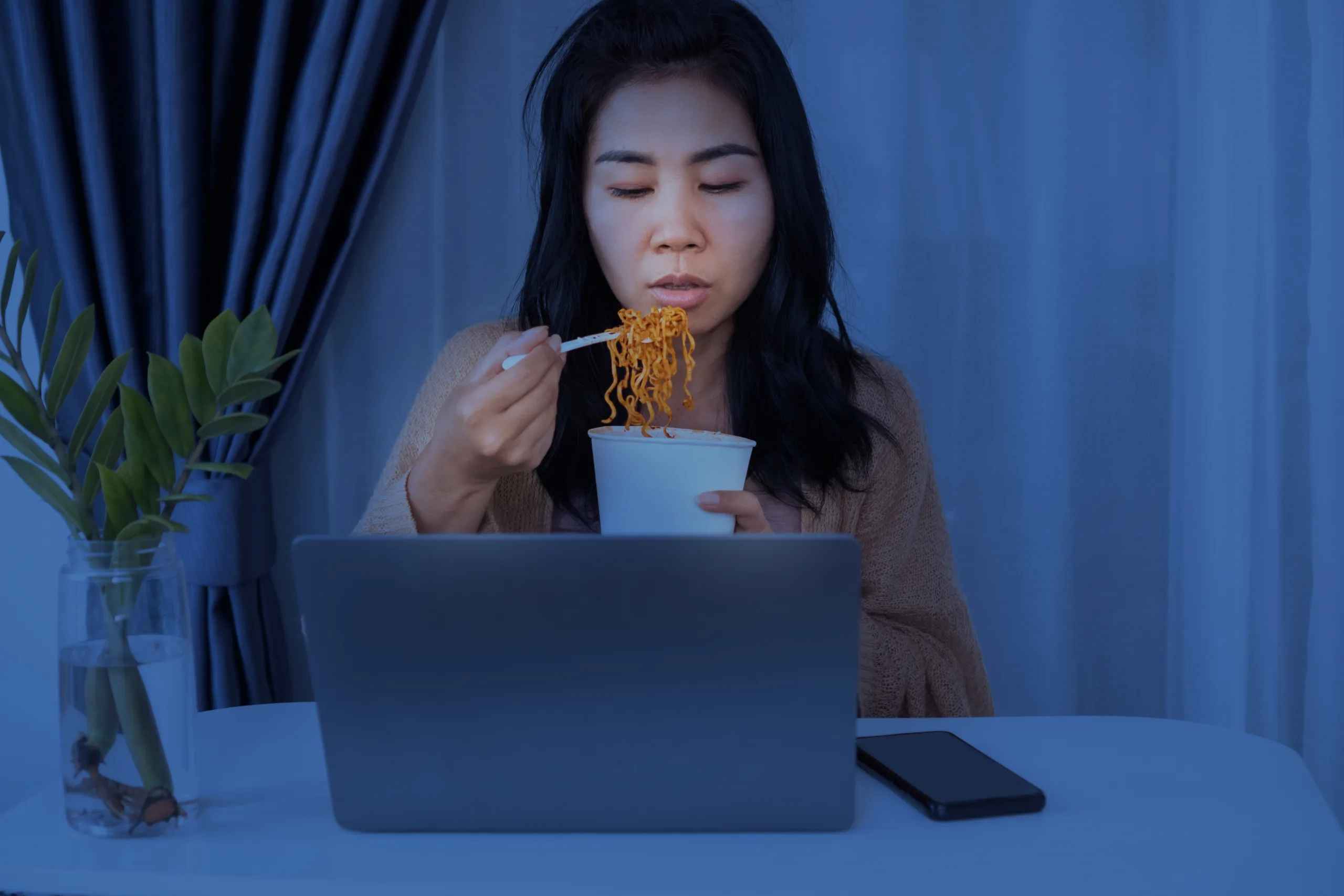 Asian businesswomen eating noodles late-night stay up to work, busy and hungry during working