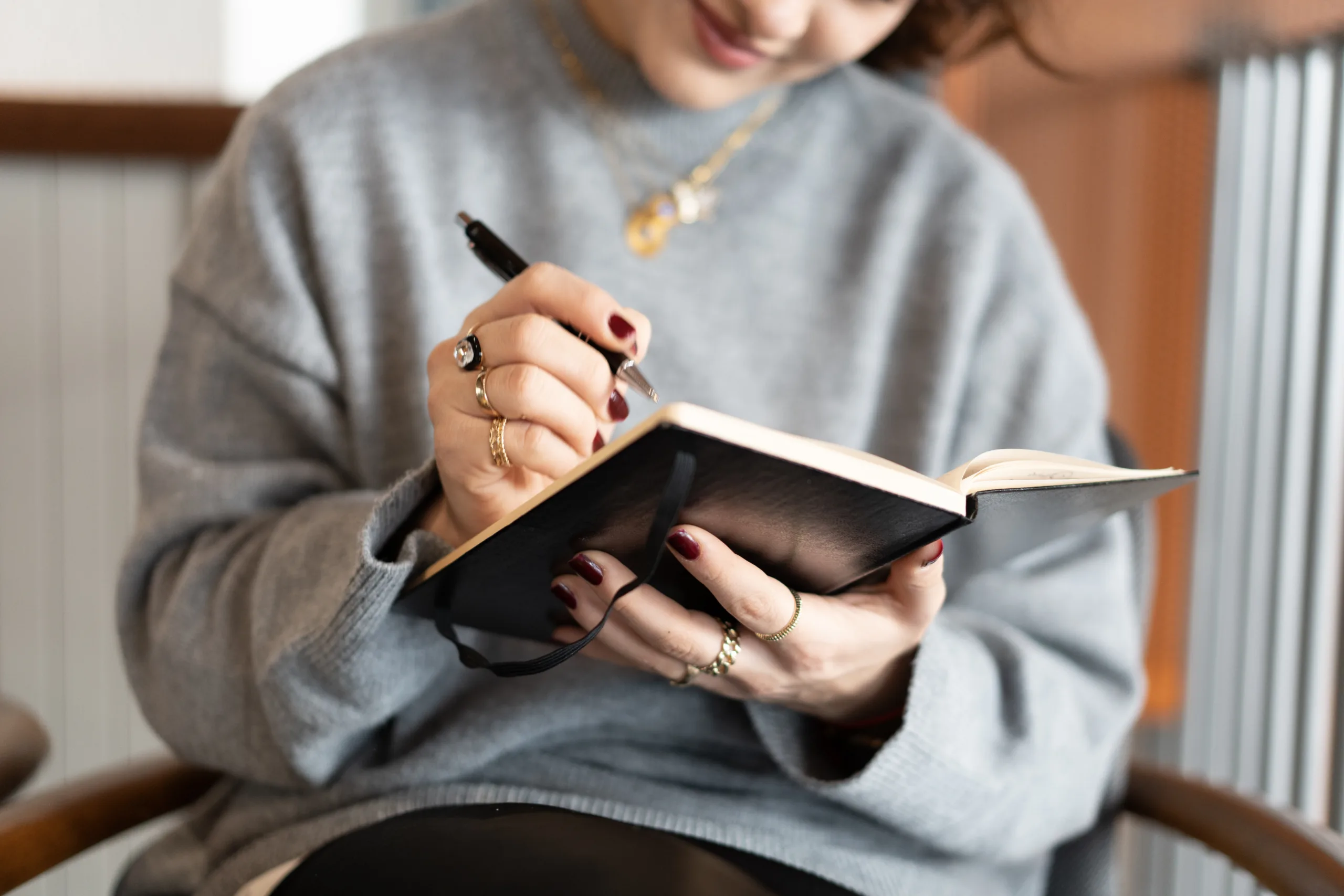 Woman taking notes in her notebook, enjoying a moment of reflection and productivity