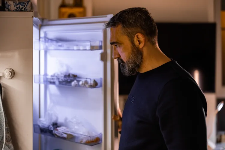 A man standing in front of the refrigerator at night struggling with EDNOS