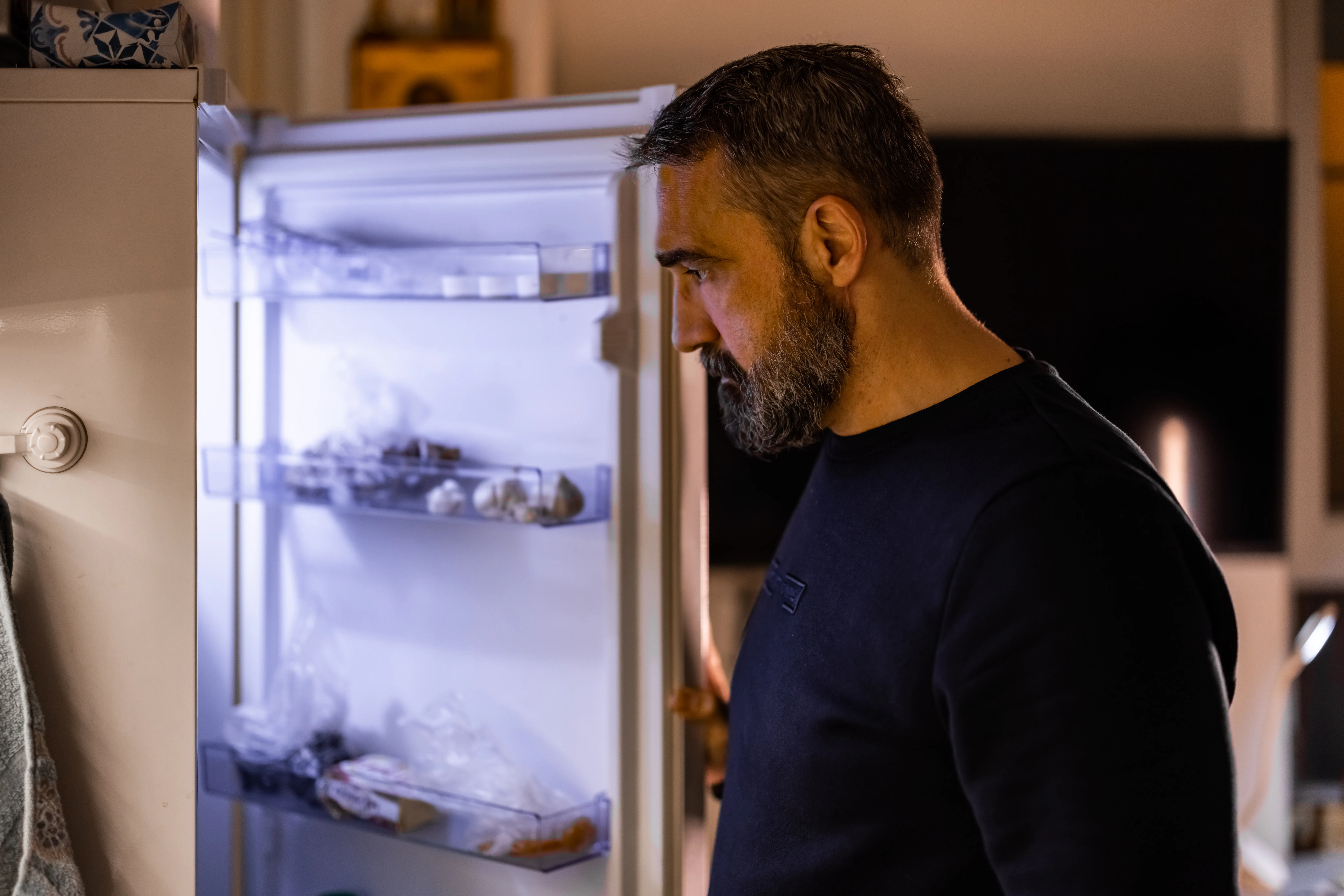 A man standing in front of the refrigerator at night struggling with EDNOS
